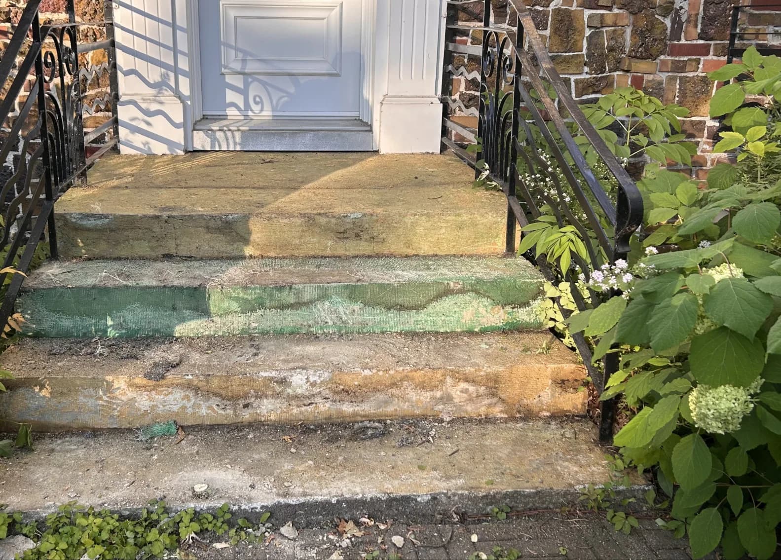 Escalier de béton usé, marches creusées et peinture écaillée, vu de face
