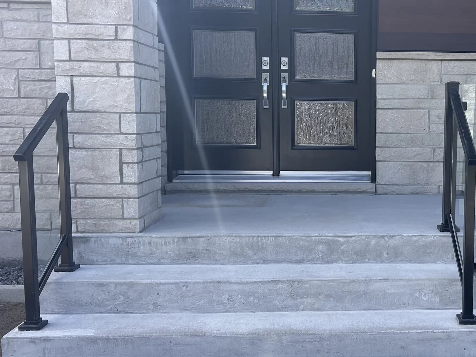 Perron de béton brut devant une porte double, avant la pose