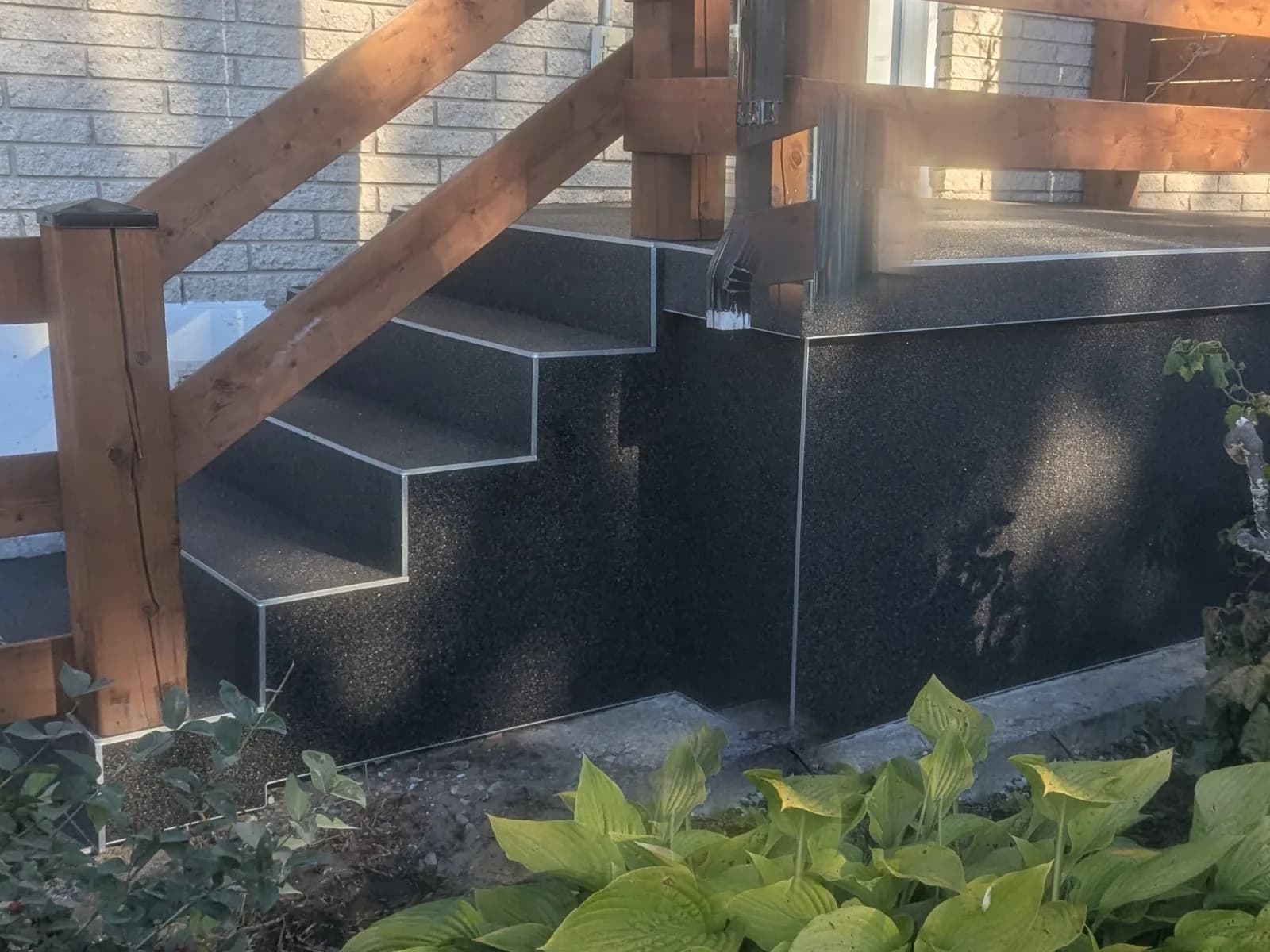Les mêmes flancs recouverts de granulux noir GLX 124, arêtes soulignées d’aluminium