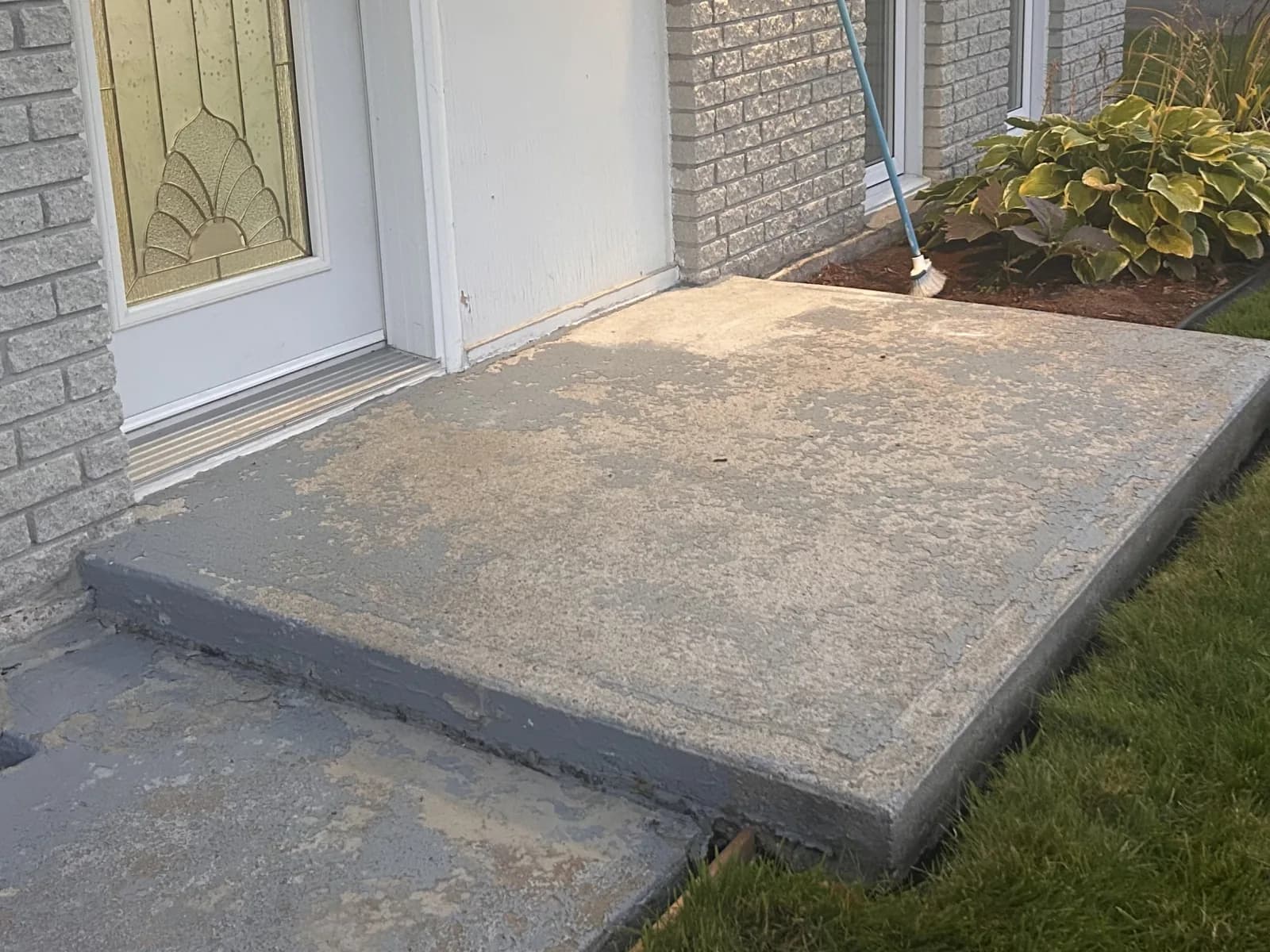 Perron de béton devant la porte, peinture grise usée